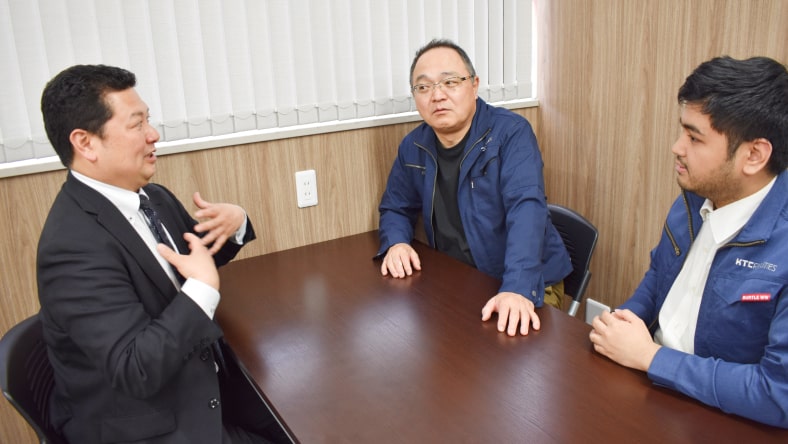 外国人男性社員と話をする日本人サポーター
